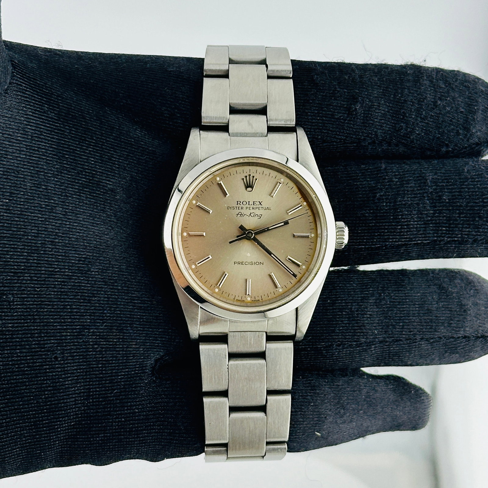 Air-King Reference 14000 Unisex Watch with Silver Dial and Oyster Bracelet: Air-King Reference 14000 Unisex Watch with Silver Dial and Oyster Bracelet This Rolex Air-King features a silver dial with a distinctive mark between the 1 and 3 positions, set within a smooth bezel. 