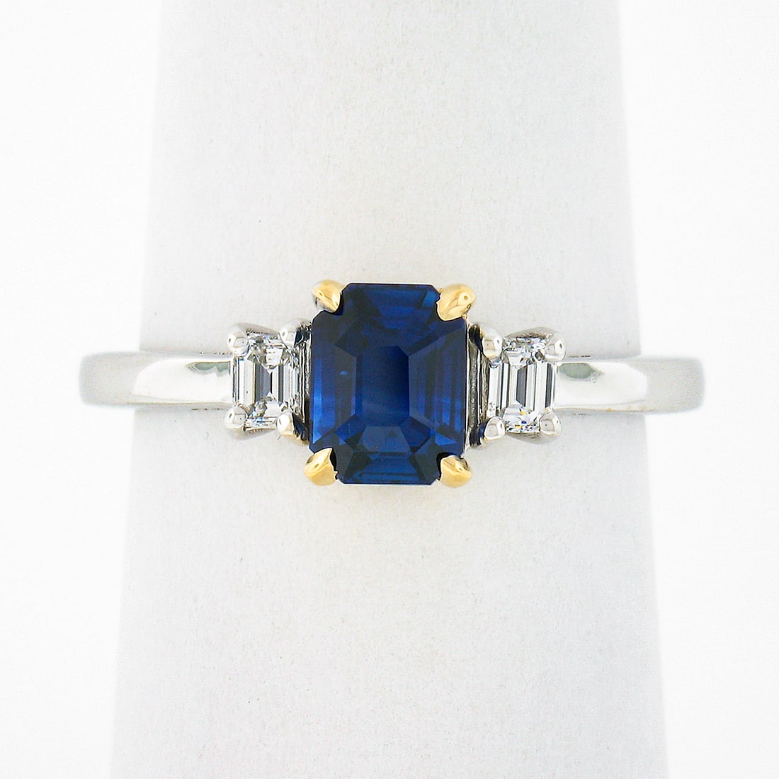 18K Gold GIA Certified 1.39ct Emerald Cut Ceylon Sapphire Diamond Three Stone Ring: 18K Gold GIA Certified 1.39ct Emerald Cut Ceylon Sapphire Diamond Three Stone Ring Introducing a stunning three-stone engagement ring crafted in solid 18K white and yellow gold. This exquisite ring fe