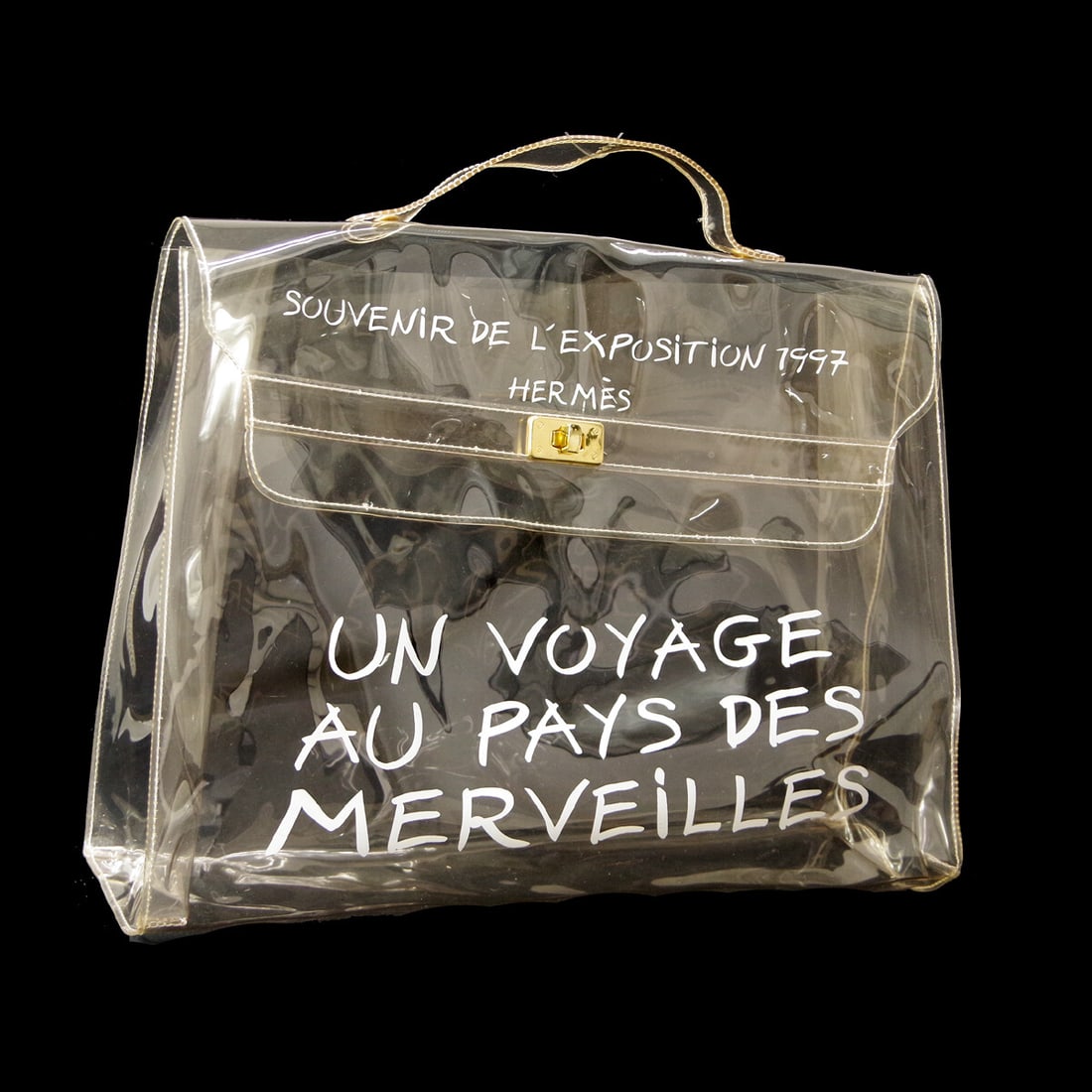 Hermes Kelly Souvenir Clear Vinyl Bag 40cm France: Hermes Kelly Souvenir Clear Vinyl Bag 40cm France This Hermes Kelly Souvenir Bag is crafted from clear plastic and designed for women. The bag features a spacious interior and is made in France. It sh