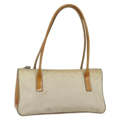 Prada Nylon Beige Silver Handbag with Guarantee Card: Prada Nylon Beige Silver Handbag with Guarantee Card This PRADA handbag features a beige nylon exterior with silver-tone accents. Designed in Italy, it offers a structured silhouette with a top handle