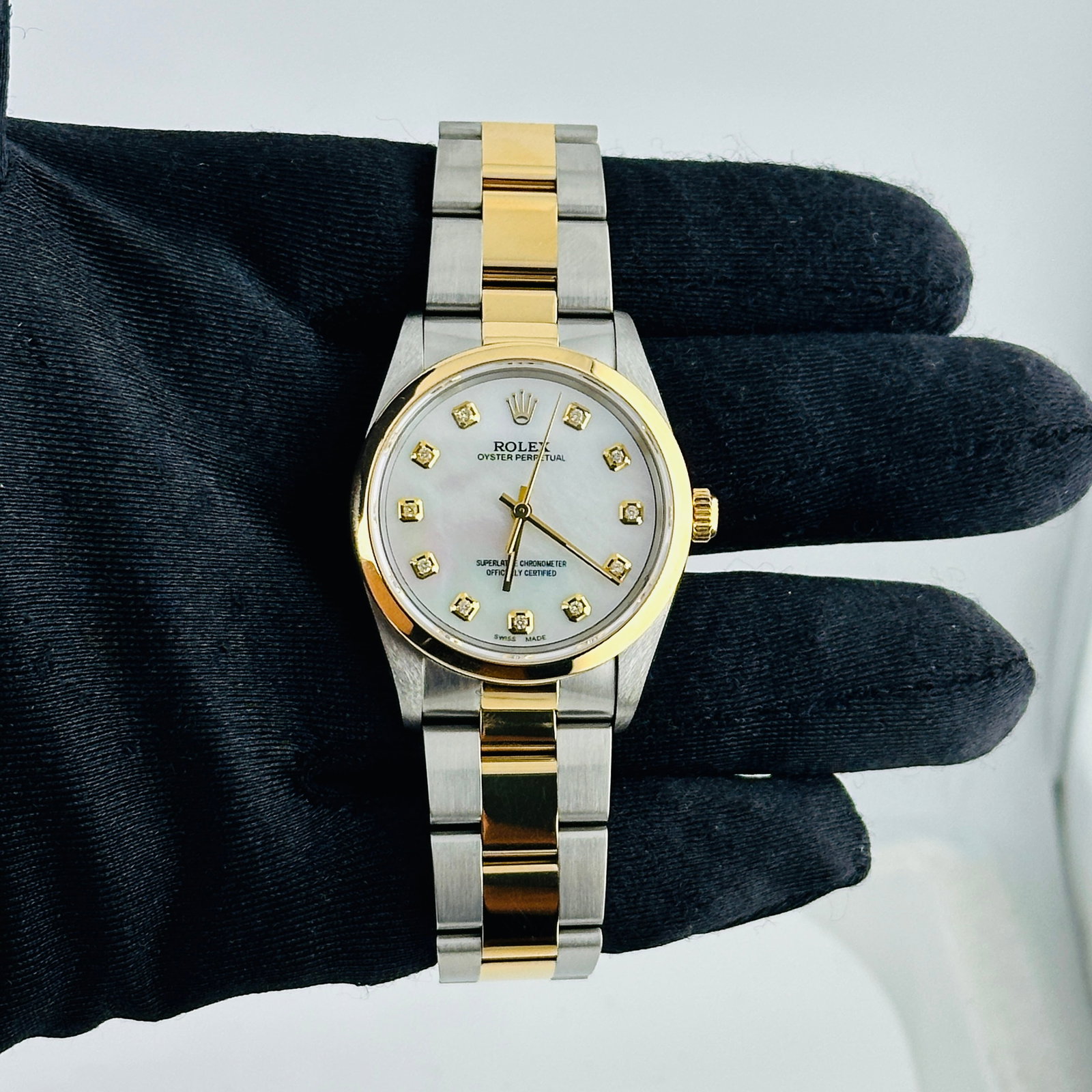 Oyster Perpetual 14203 White MOP Diamond Dial Watch With Papers 1994: Oyster Perpetual 14203 White MOP Diamond Dial Watch With Papers 1994 This Rolex Oyster Perpetual features an Aftermarket white mother-of-pearl diamond dial and a smooth bezel. The watch comes from the