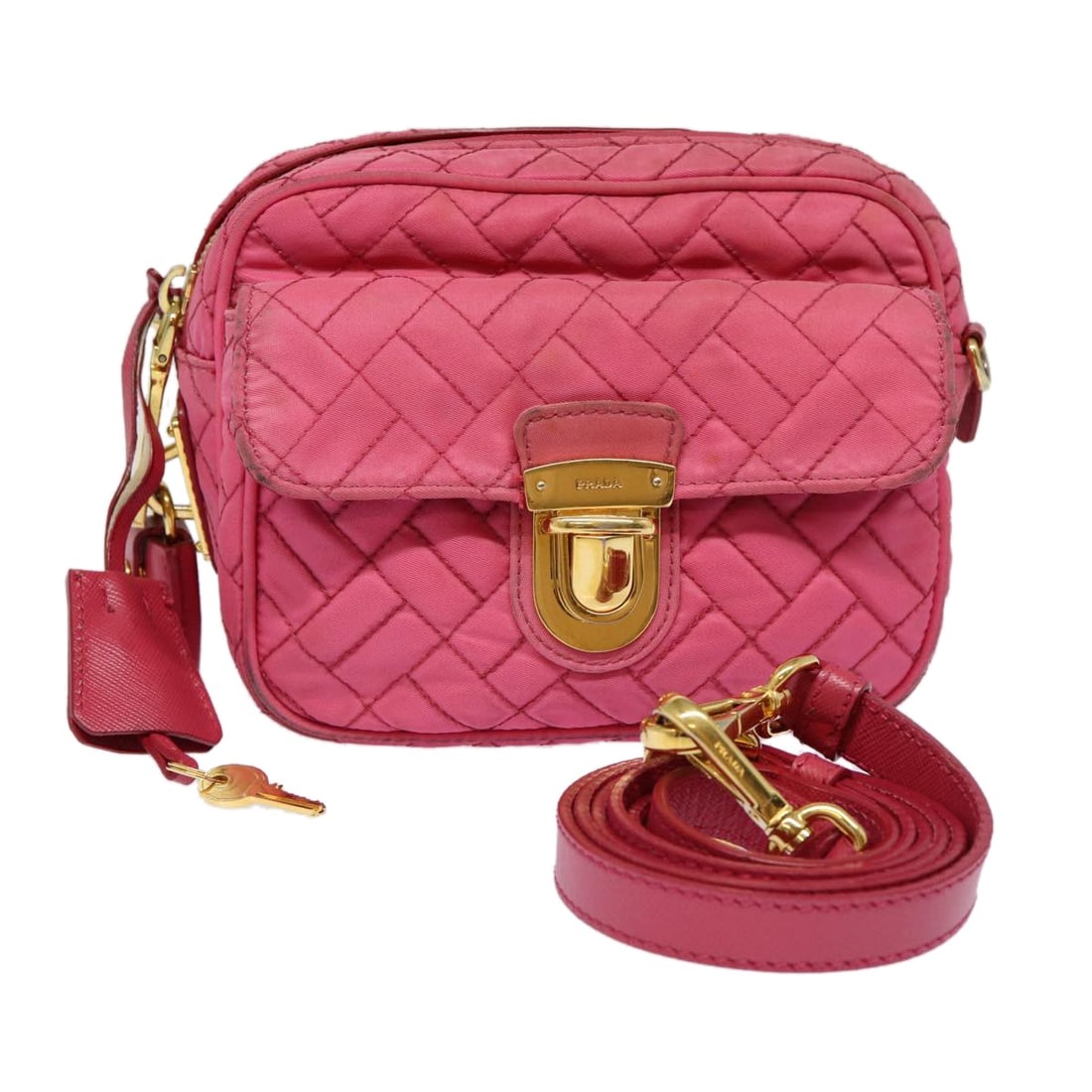 Pink Nylon Prada Shoulder Bag with Padlock and Keys: Pink Nylon Prada Shoulder Bag with Padlock and Keys This PRADA quilted shoulder bag is crafted from durable nylon in a pink and gold color combination. Designed for women, it features a compact profil