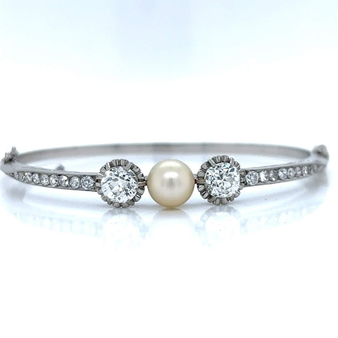 Antique Platinum Bangle with Natural Pearl and Diamonds: Antique Platinum Bangle with Natural Pearl and Diamonds Discover this exquisite Antique Platinum Bangle, featuring a stunning natural pearl and a captivating diamond arrangement. The bangle showcases 