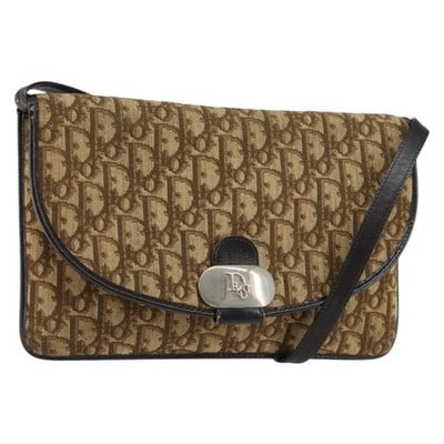 Christian Dior Beige Gold Trotter Canvas Shoulder Bag: Christian Dior Beige Gold Trotter Canvas Shoulder Bag This Christian Dior Trotter Canvas Shoulder Bag features a beige and gold color scheme with the signature Trotter canvas material. Designed as a s