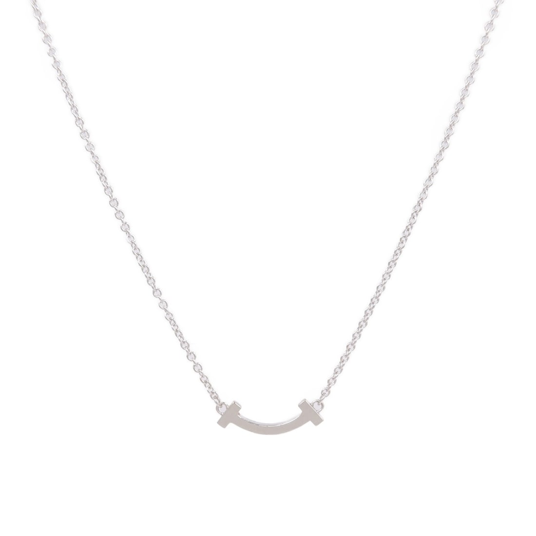 Tiffany Co T Smile Small 18K White Gold Necklace: Tiffany Co T Smile Small 18K White Gold Necklace This Tiffany & Co. T Smile Small Necklace features a sleek design crafted in 18K white gold with a silver appearance. Designed for women, it offers a r