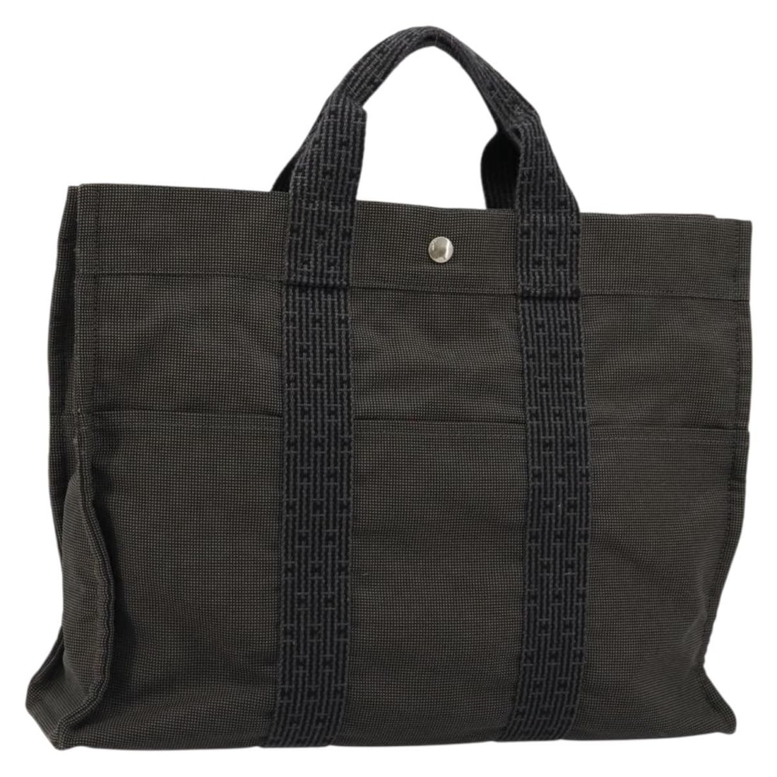 Hermes Her Line MM gray silver canvas handbag: Hermes Her Line MM gray silver canvas handbag This Hermes Her Line MM hand bag is crafted from gray and silver canvas, offering a stylish and practical accessory for everyday use. Made in France, it f