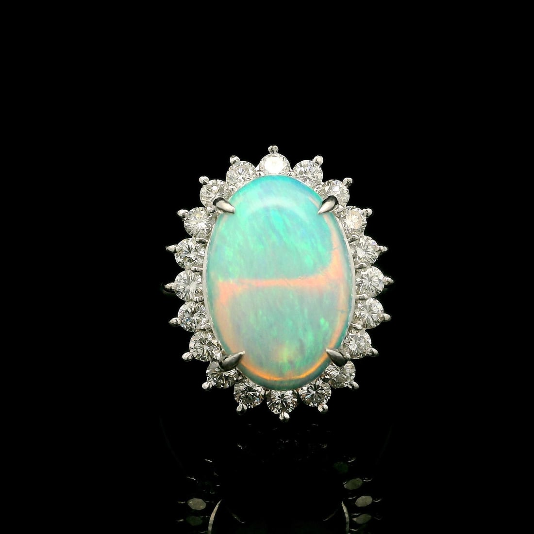 Elegant Platinum 3.90ctw Oval Opal Diamond Halo Cocktail Ring: Elegant Platinum 3.90ctw Oval Opal Diamond Halo Cocktail Ring This exquisite cocktail ring showcases a classic design in solid platinum featuring a stunning elongated oval opal at its center. The opal