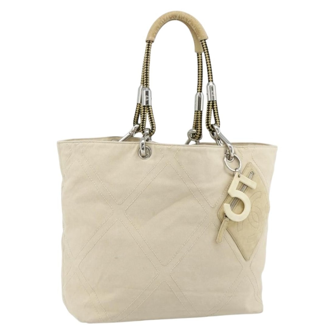 CHANEL Ivory Canvas Tote with Charm Silver CC: CHANEL Ivory Canvas Tote with Charm Silver CC This CHANEL tote bag is crafted from canvas in an ivory and silver color scheme. Designed for women, it features a spacious interior and comes with a char