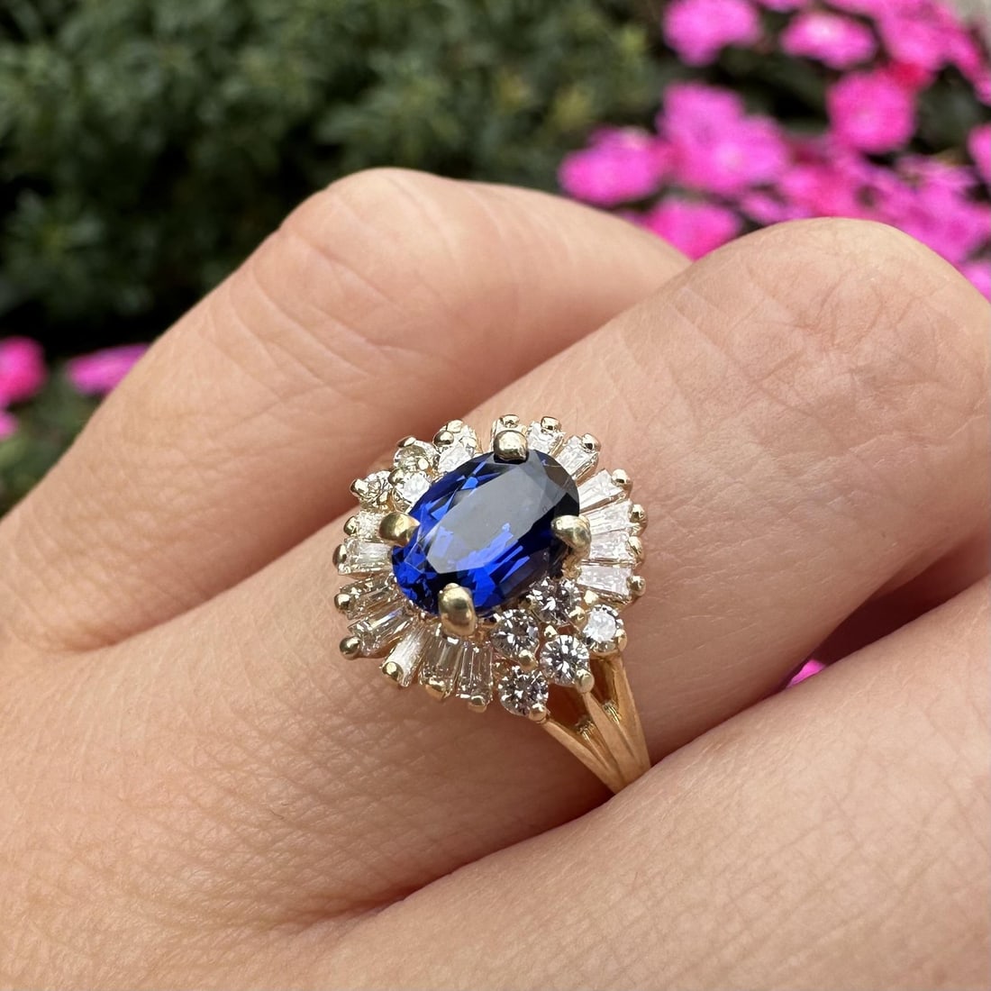 14k Yellow Gold Mini Ballerina Ring with Royal Blue Stone and Diamond Halo: 14k Yellow Gold Mini Ballerina Ring with Royal Blue Stone and Diamond Halo This exquisite mini ballerina ring showcases a stunning oval royal blue stone, measuring approximately 7x4.9mm, elegantly pro