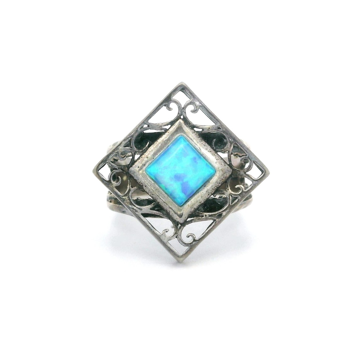Vintage Sterling Silver Cocktail Ring with Blue Synthetic Opal: Vintage Sterling Silver Cocktail Ring with Blue Synthetic Opal This exquisite vintage cocktail ring features a stunning synthetic opal, showcasing a captivating blue base with vibrant green color play