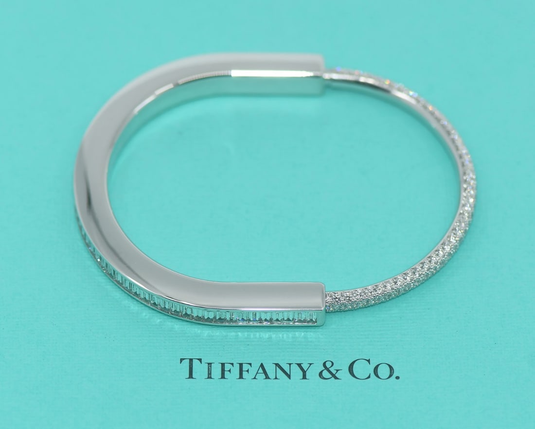 Tiffany & Co Lock XL Diamond Baguette 18K White Gold Bangle Bracelet: Tiffany & Co Lock XL Diamond Baguette 18K White Gold Bangle Bracelet This stunning Tiffany & Co. Lock XL bracelet is crafted from luxurious 18K white gold, showcasing a chic bangle style adorned with 