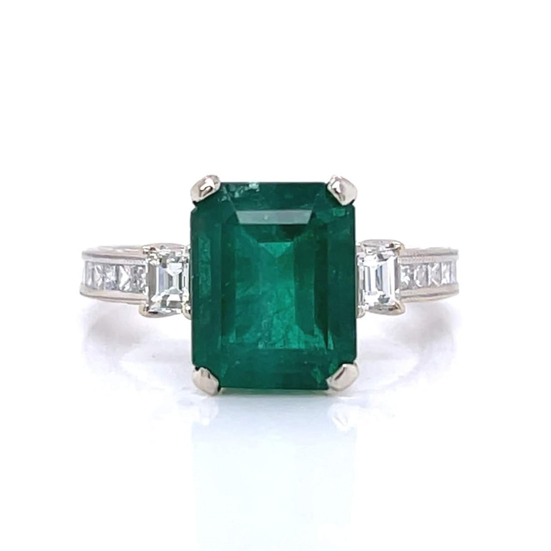 Elegant 18K White Gold 4.12 Ct Emerald Diamond Ring: Elegant 18K White Gold 4.12 Ct Emerald Diamond Ring This stunning ring features a vibrant 4.12 Ct. emerald elegantly set in 18K white gold. Complementing the emerald are 18 sparkling diamonds, with a 