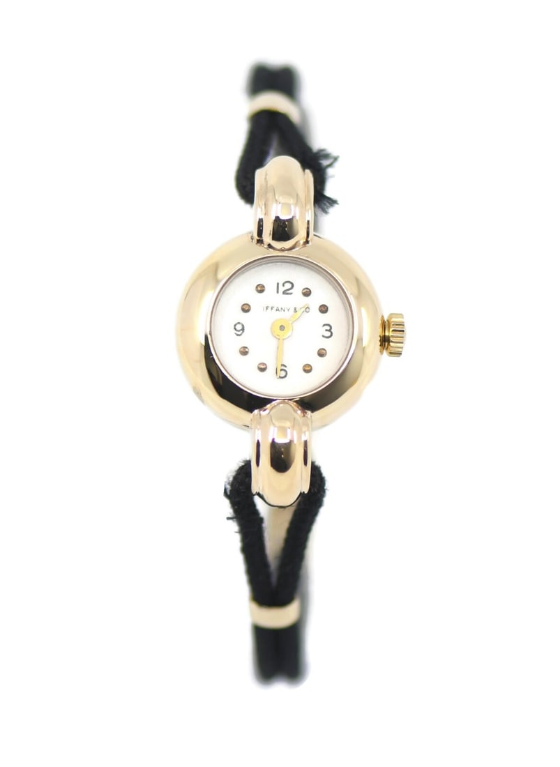 Tiffany & Co 14K Yellow Gold Mechanical Wristwatch Black Band: Tiffany & Co 14K Yellow Gold Mechanical Wristwatch Black Band Experience timeless elegance with this Tiffany & Co. 14K Yellow Gold Wristwatch. Featuring a classic manual mechanical movement, this exqu