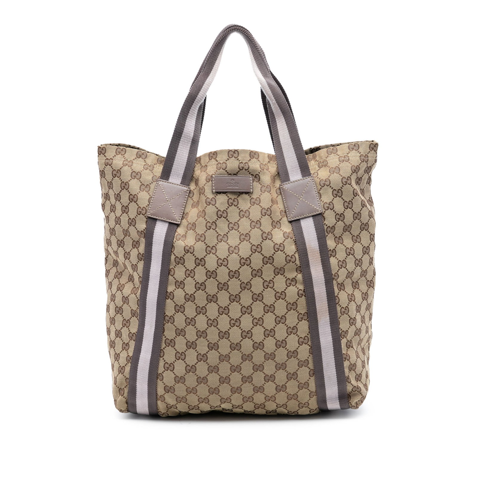 GG Canvas Web Tote Bag by Gucci in Beige Fabric: GG Canvas Web Tote Bag by Gucci in Beige Fabric This Gucci GG Canvas Web Tote features a beige canvas body with flat straps, an open top, and interior slip pockets. The bag shows signs of wear on the 