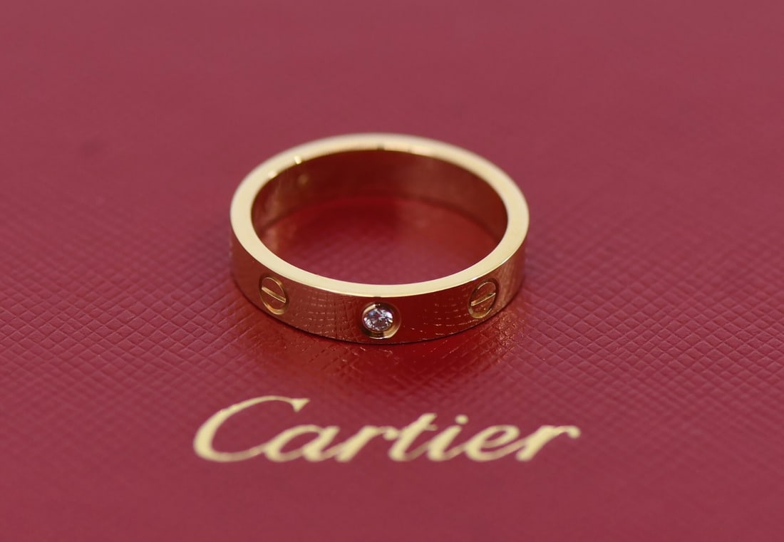 18K Yellow Gold Cartier Love Ring with Diamond Size 54: 18K Yellow Gold Cartier Love Ring with Diamond Size 54 This Cartier Love ring is crafted from 18K yellow gold and features a diamond accent. The ring is a size 54 (US size 7) with a width of 4mm. It c
