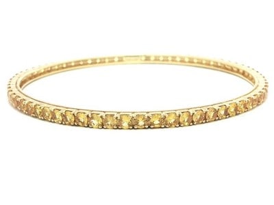 Yellow Sapphire Tennis Bangle in 18k Yellow Gold Slip On: Yellow Sapphire Tennis Bangle in 18k Yellow Gold Slip On This elegant eternity tennis bangle bracelet features numerous round brilliant cut natural sapphires in vivid yellow hues, each prong set to sh