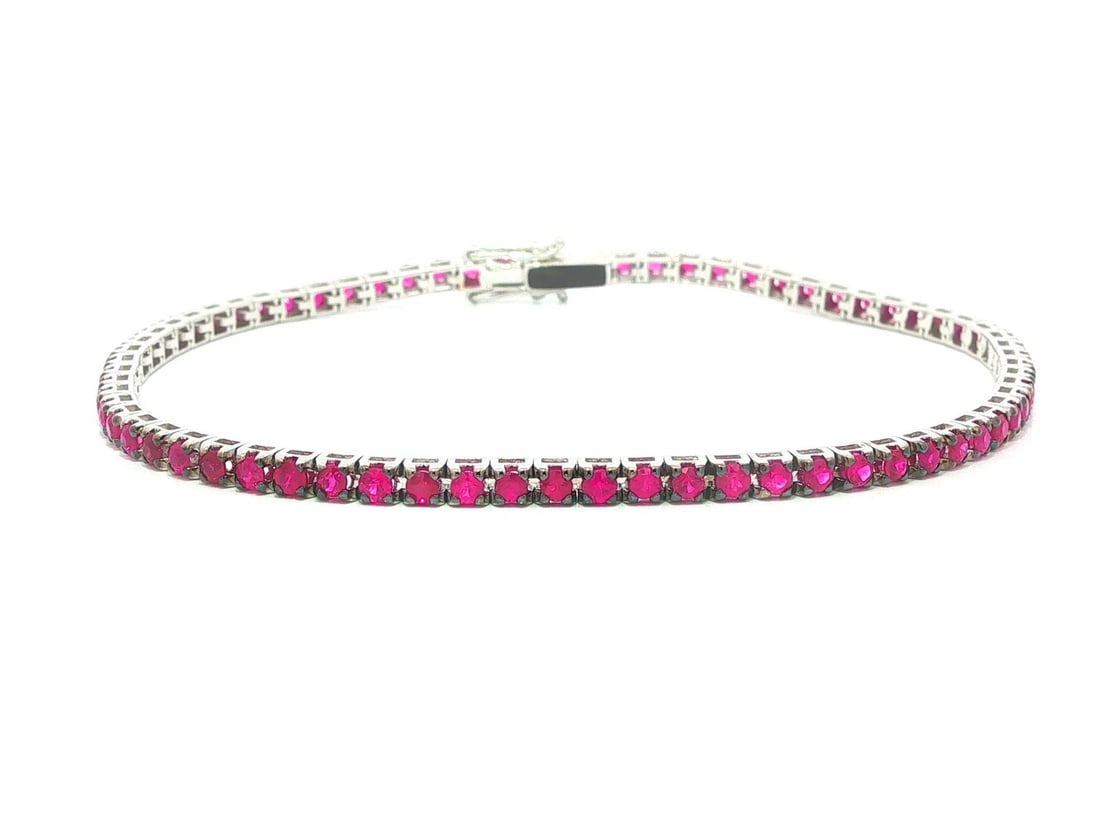 18k White Gold Ruby Tennis Bracelet 2.4ctw 7 Inch: 18k White Gold Ruby Tennis Bracelet 2.4ctw 7 Inch This un-used tennis bracelet features 68 natural, genuine round brilliant cut rubies with a vivid pinkish red color, totaling exactly 2.40 carats. The