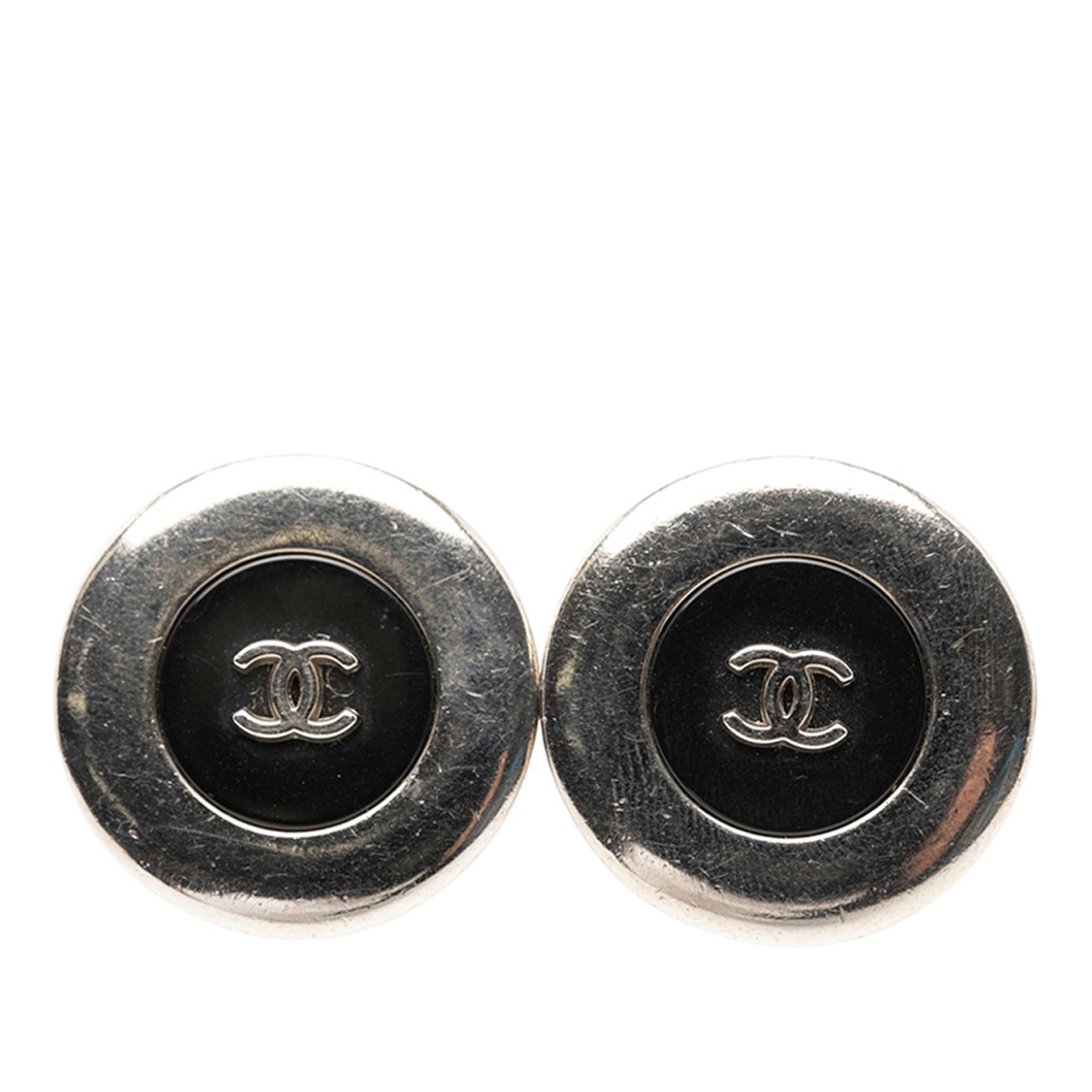 Chanel CC Logo Silver Tone Round Clip On Button Earrings: Chanel CC Logo Silver Tone Round Clip On Button Earrings These Chanel clip-on earrings feature a round button design with the iconic CC logo, crafted from silver tone metal and resin. Made in France, 