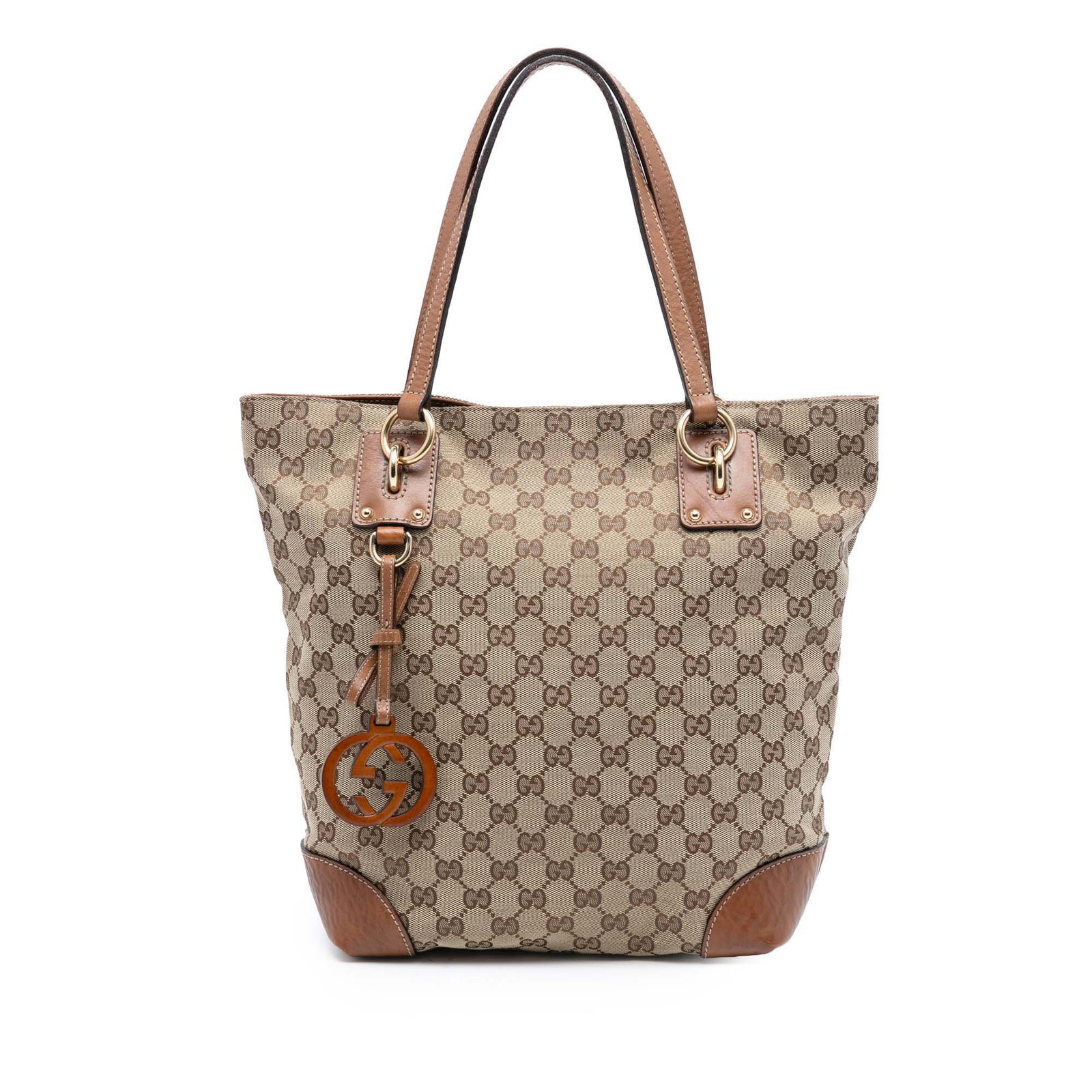 Medium Brown GG Canvas Tote with Leather Trim and GG Charm by Gucci: Medium Brown GG Canvas Tote with Leather Trim and GG Charm by Gucci This Gucci Medium GG Canvas GG Charm Tote features a brown canvas body with leather trim and a signature GG charm. The bag is design