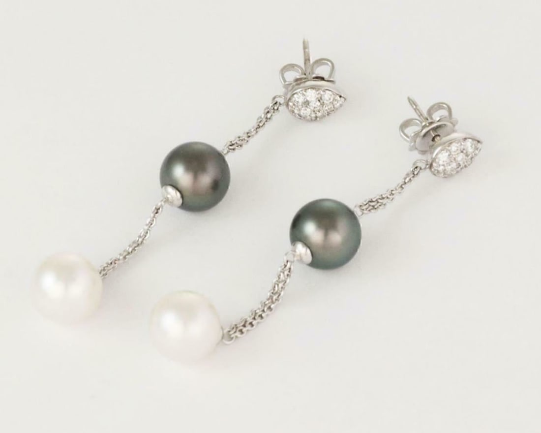 Vintage 18k White Gold Pearl Diamond Dangle Earrings: Vintage 18k White Gold Pearl Diamond Dangle Earrings This pair of vintage dangle earrings features gray Tahitian and white pearls, each measuring 8.8mm, set in 18k white gold. The design includes a do