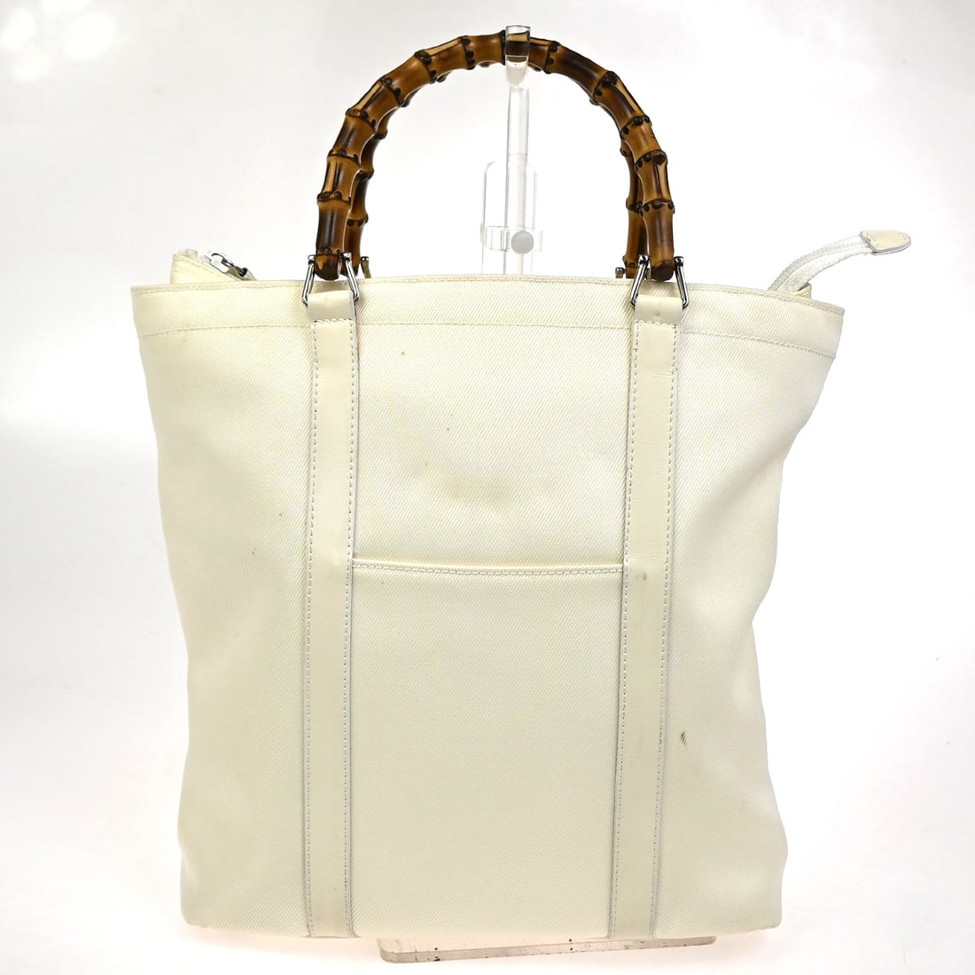 Gucci White Nylon Convertible Tote with Bamboo Accents: Gucci White Nylon Convertible Tote with Bamboo Accents This Gucci Convertible Bamboo Zip Tote is crafted from white nylon and designed for women. It features bamboo detailing and a zip closure. The ba