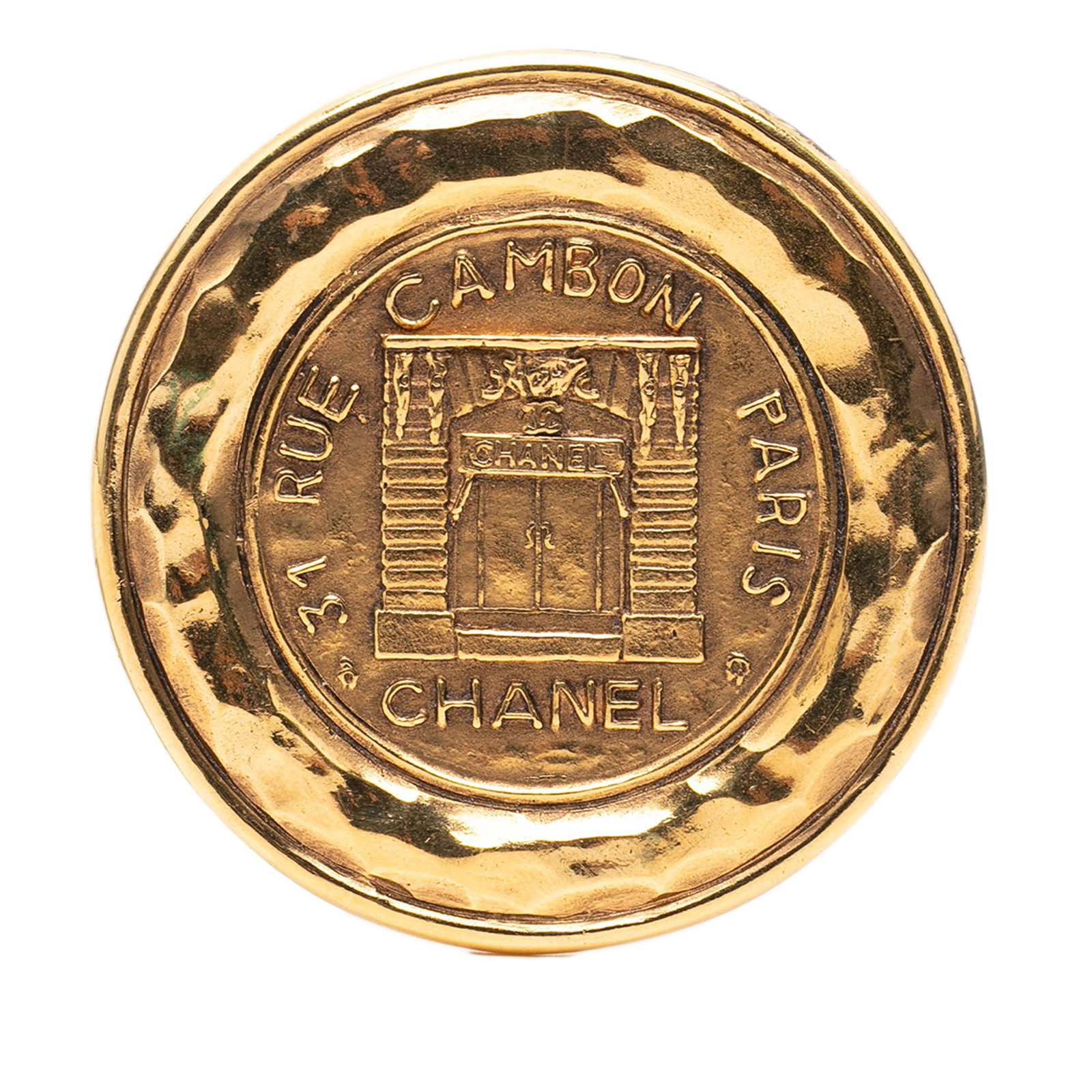 Chanel 31 Rue Cambon Gold Tone Round Metal Brooch: Chanel 31 Rue Cambon Gold Tone Round Metal Brooch This Chanel brooch features a round design crafted from gold-tone metal. It is equipped with a back pin closure and displays the iconic 31 Rue Cambon 