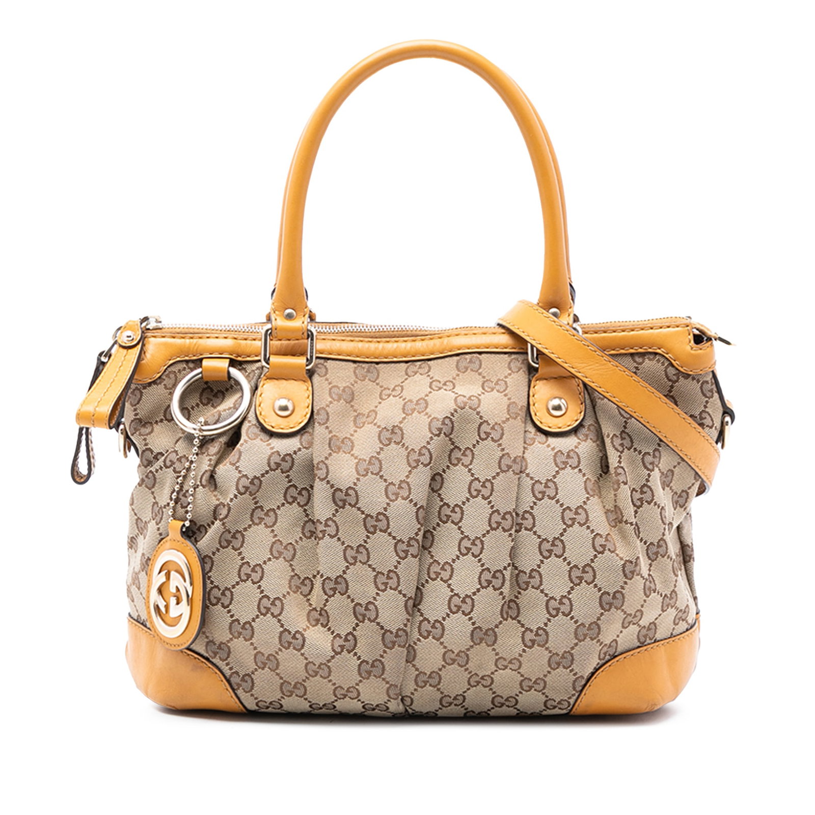 Gucci Sukey Satchel in Beige GG Canvas with Leather Trim: Gucci Sukey Satchel in Beige GG Canvas with Leather Trim The Gucci GG Canvas Sukey Satchel showcases a beige canvas body with leather trim, rolled leather handles, and a detachable leather shoulder st