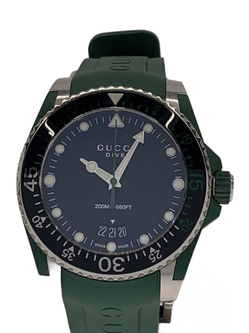 Gucci Dive Green Quartz Men's Wristwatch YA136310: Gucci Dive Green Quartz Men's Wristwatch YA136310 This is a pre-owned GUCCI DIVE Quartz YA136310 men's wristwatch featuring a green color scheme. The watch is Swiss-made and is in slightly used condit