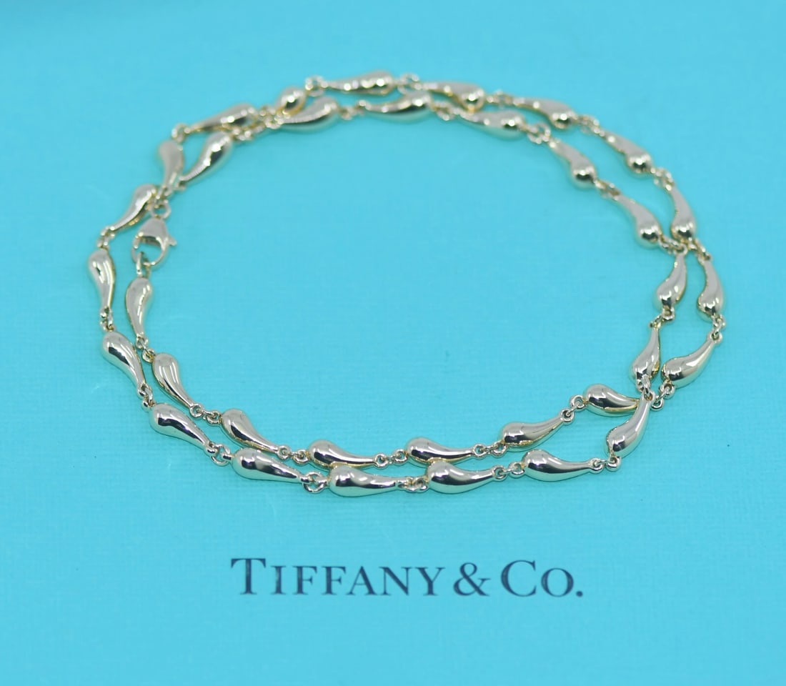 Tiffany & Co Elsa Peretti Teardrop 18K Yellow Gold Charm Necklace: Tiffany & Co Elsa Peretti Teardrop 18K Yellow Gold Charm Necklace Elevate your jewelry collection with the Tiffany & Co. Elsa Peretti Teardrop Necklace, crafted from luxurious 18K yellow gold. This ex