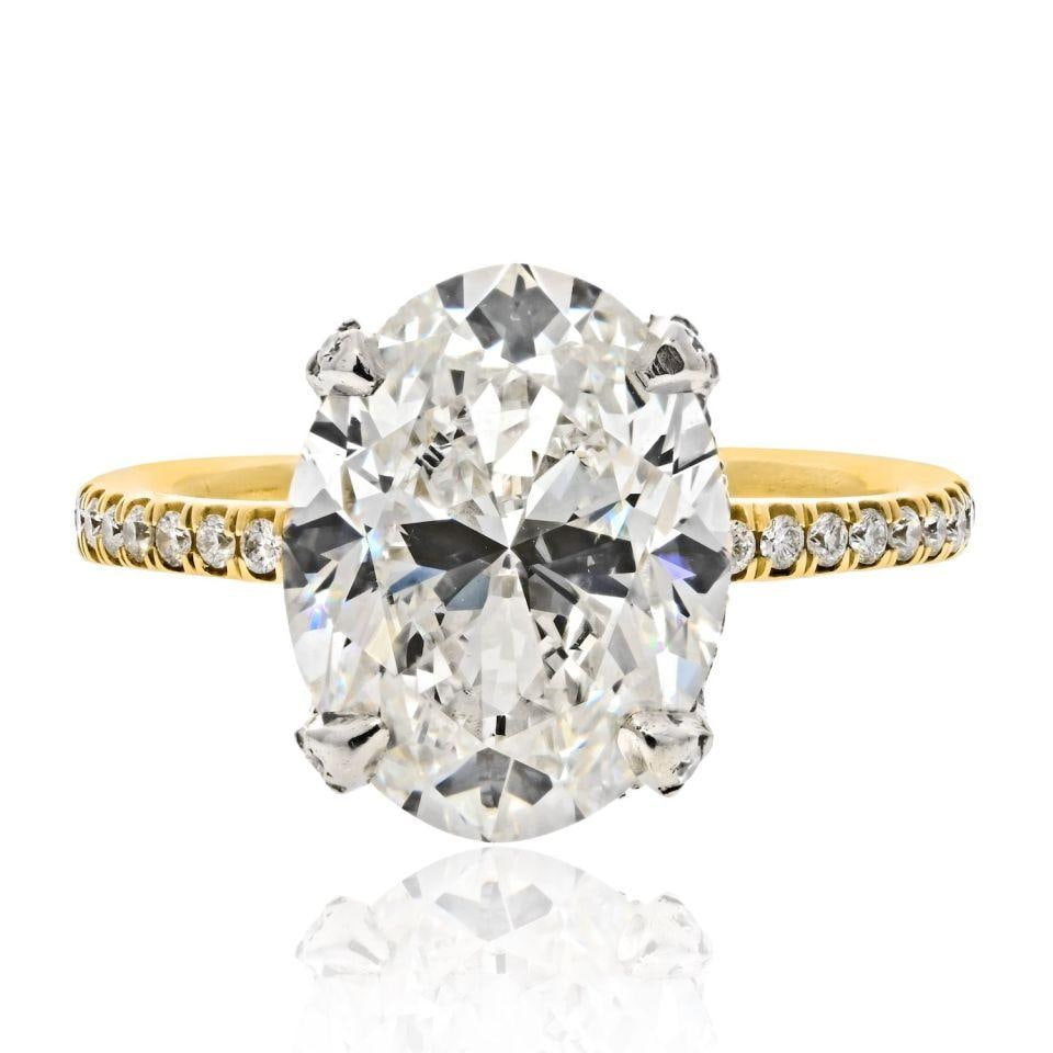Oval Cut 5ct J VS1 GIA Diamond Engagement Ring with Hidden Halo in 14K Gold: Oval Cut 5ct J VS1 GIA Diamond Engagement Ring with Hidden Halo in 14K Gold This elegant engagement ring features a 5 carat oval cut diamond set in 14K yellow gold. The center diamond is GIA certified