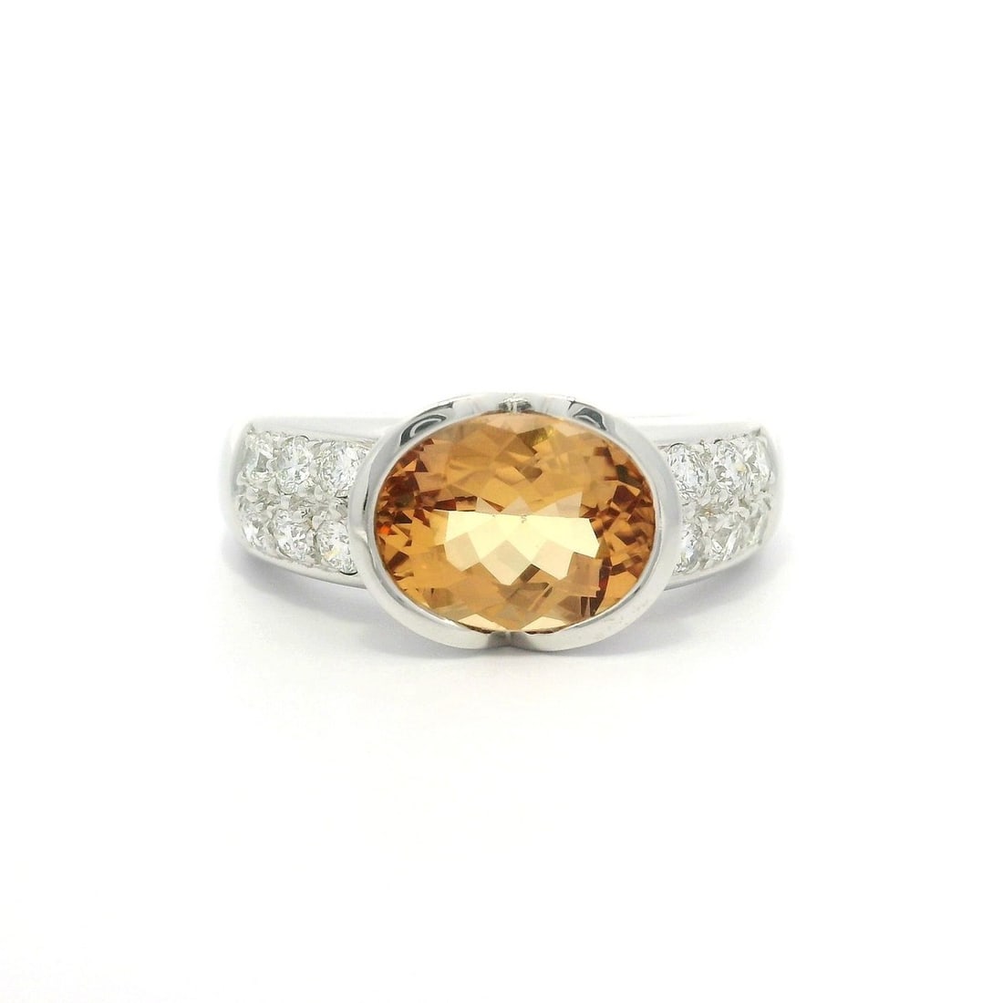 GIA Certified 18k White Gold Topaz Diamond Band Ring 5.5: GIA Certified 18k White Gold Topaz Diamond Band Ring 5.5 This elegant band ring features a genuine oval brilliant cut precious topaz in a brownish orange hue, weighing exactly 2.0 carats, set in solid