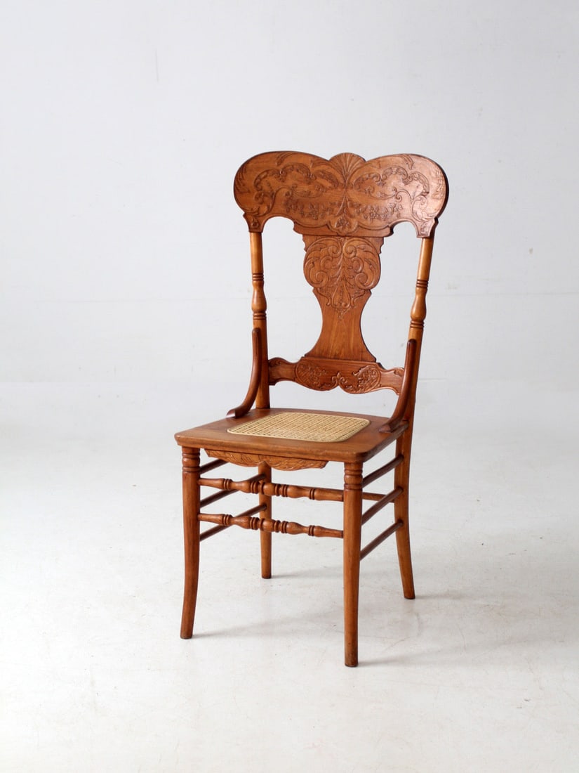 Victorian Oak Pressed Back Chair Featuring Replacement Cane Seat: Victorian Oak Pressed Back Chair Featuring Replacement Cane Seat This antique Late Victorian pressed back chair features an elegant oak frame with scrolling detail and a classic cane seat. The chair h