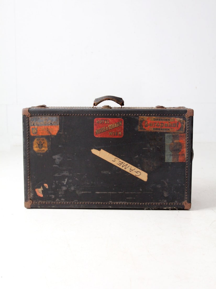 Early 20th Century Black Leather Travel Case With European Hotel Labels: Early 20th Century Black Leather Travel Case With European Hotel Labels This early 20th-century antique leather suitcase showcases a rich history of travel, adorned with original labels from European 