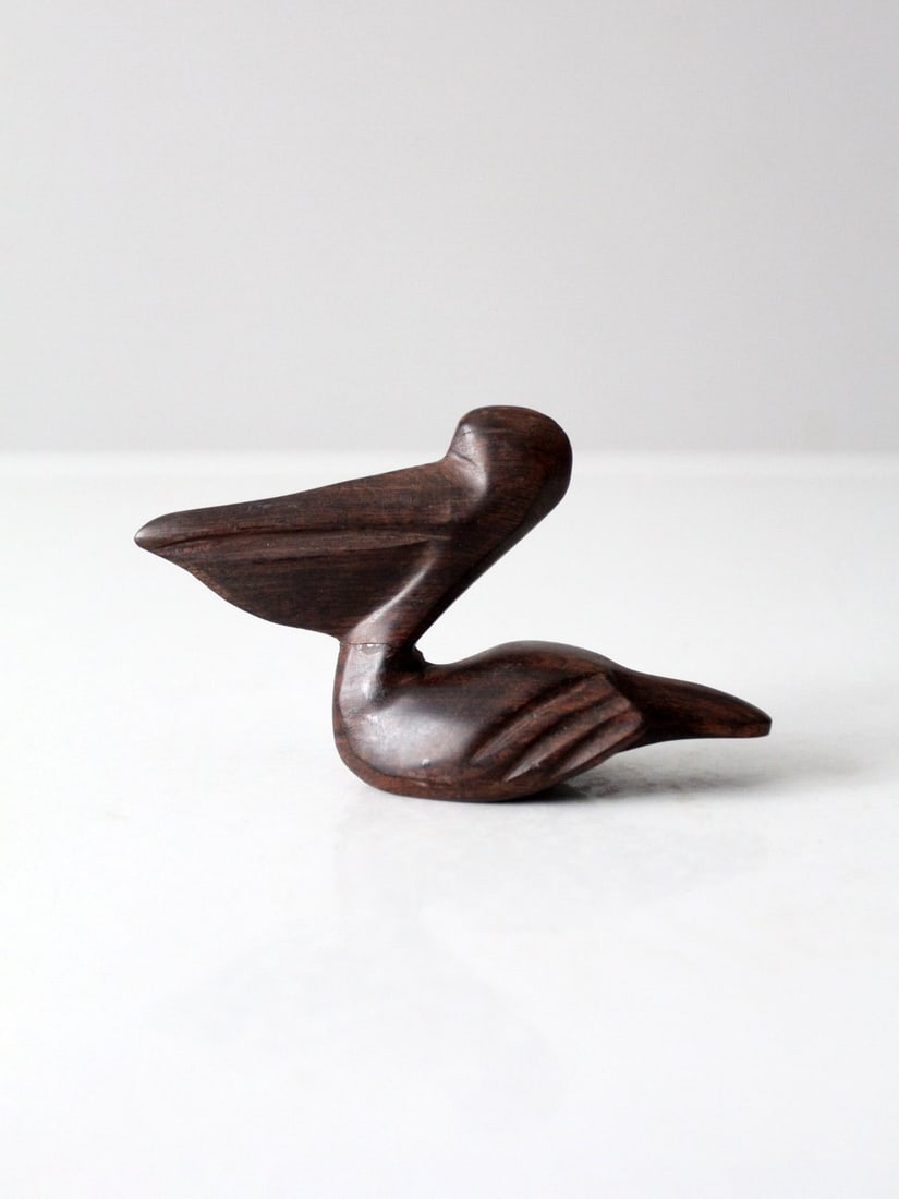 Hand-Carved Mid-Century Ironwood Pelican Sculpture: Hand-Carved Mid-Century Ironwood Pelican Sculpture Enhance your home with this vintage hand-carved ironwood pelican figurine, a perfect blend of coastal charm and artisan craftsmanship. This