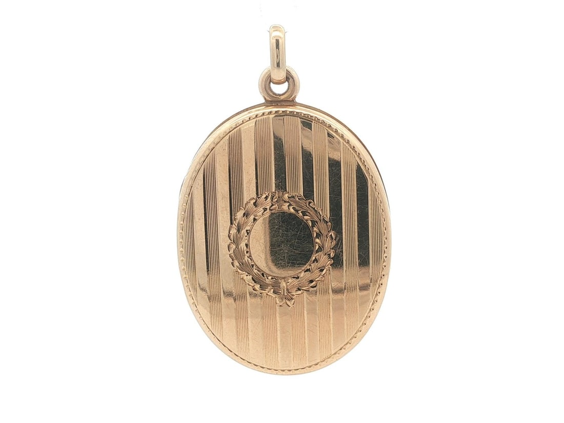 Large Vintage Oval Locket Pendant in 14k Yellow Gold Grooved Design: Large Vintage Oval Locket Pendant in 14k Yellow Gold Grooved Design This vintage locket pendant features a large, oval design crafted from solid 14k yellow gold with grooved detailing. It includes a c