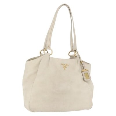 PRADA Leather Ivory Gold Tote Bag with Name Tag: PRADA Leather Ivory Gold Tote Bag with Name Tag This PRADA tote bag features an ivory and gold color scheme and is crafted from leather. The bag includes a name tag accessory and was made in Turkey. I