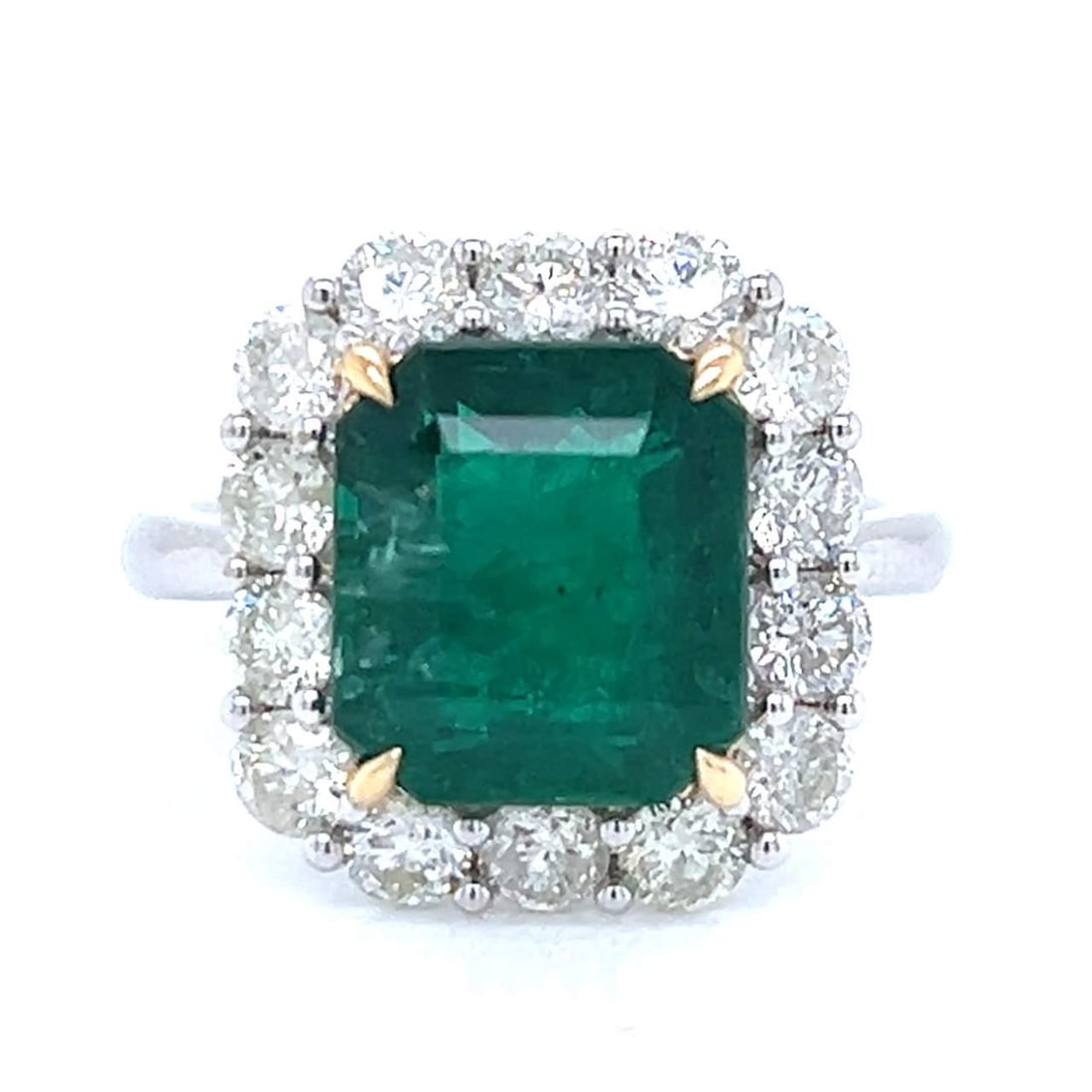 18K White Gold Emerald 4.79 Ct with 14 Diamonds Ring: 18K White Gold Emerald 4.79 Ct with 14 Diamonds Ring This exquisite 18K white gold ring features a stunning 4.79 Ct. emerald at its center, complemented by 14 dazzling diamonds totaling 1.53 Ct. The d