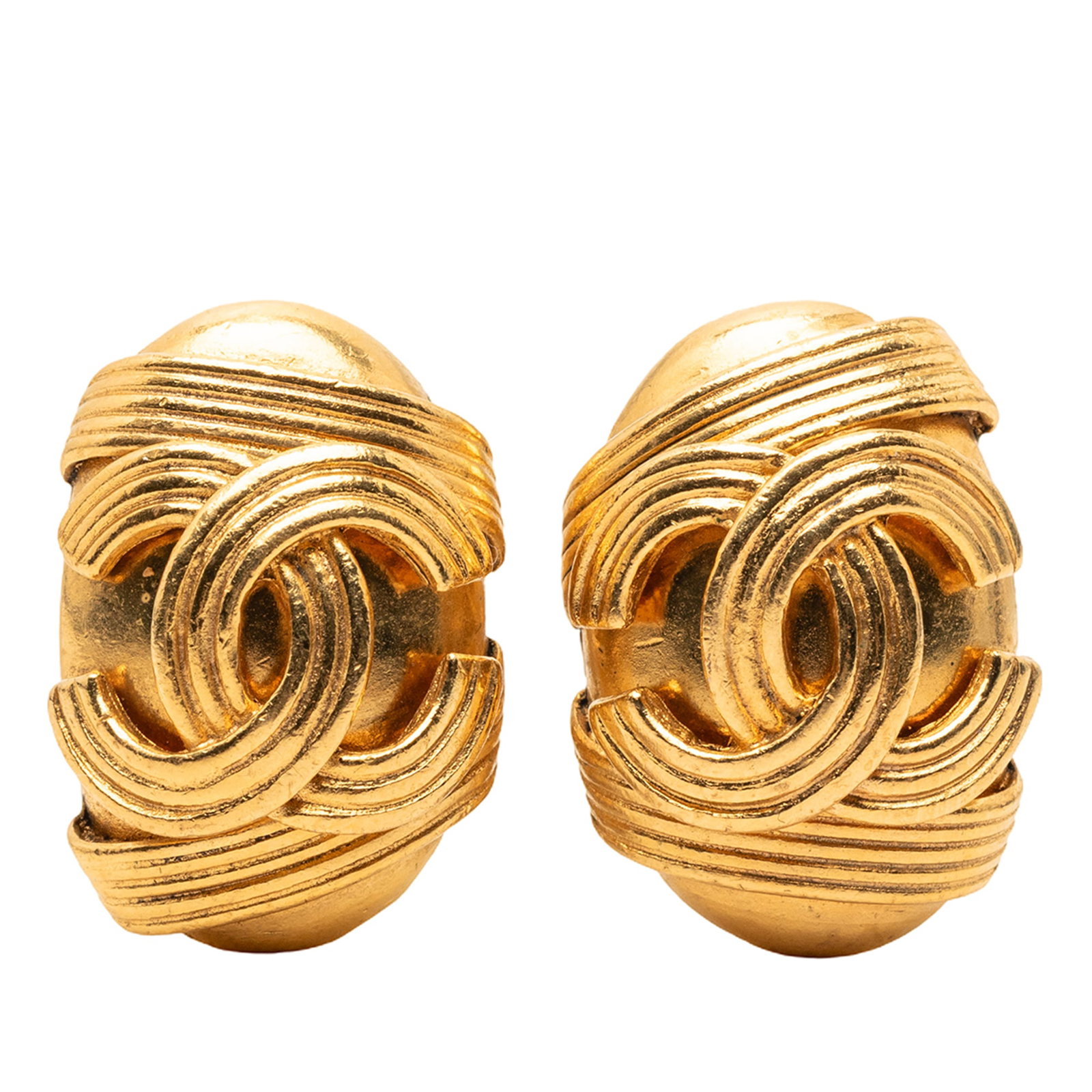 Chanel CC Oval Gold Tone Clip On Earrings: Chanel CC Oval Gold Tone Clip On Earrings These Chanel CC Oval Clip On Earrings feature a gold-tone metal body with clip-on closures. Crafted in France, these costume earrings display the iconic Chane