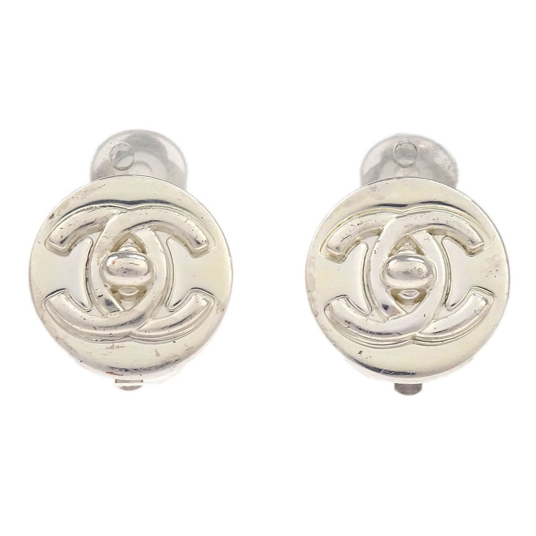 Chanel 97A Silver Plated Clip-On Button Earrings: Chanel 97A Silver Plated Clip-On Button Earrings Discover the elegance of these Chanel Turnlock Button Earrings. Crafted with a silver plated finish, these round clip-on earrings feature a chic button