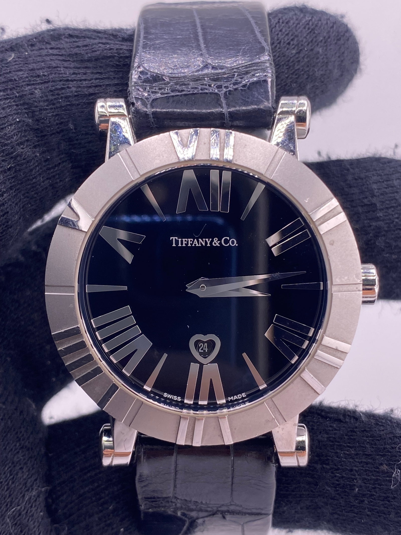 Tiffany & Co Atlas black dial leather watch TIF345711: Tiffany & Co Atlas black dial leather watch TIF345711 This Tiffany & Co. Atlas watch features a black dial and a leather bracelet, offering a classic and sophisticated look. The timepiece is identifie