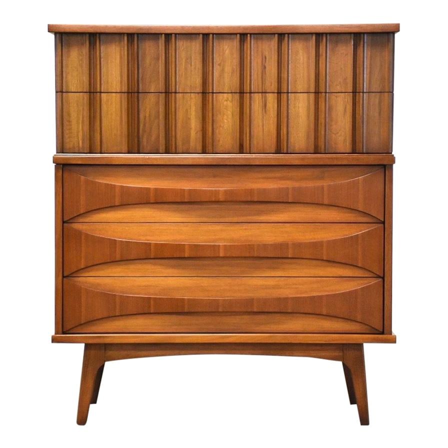 Mid Century Modern Walnut Tall Dresser with Sculpted Drawer Pulls: Mid Century Modern Walnut Tall Dresser with Sculpted Drawer Pulls This mid century modern tall dresser showcases a rich walnut finish and features beautifully sculpted bent wood drawer pulls for an el