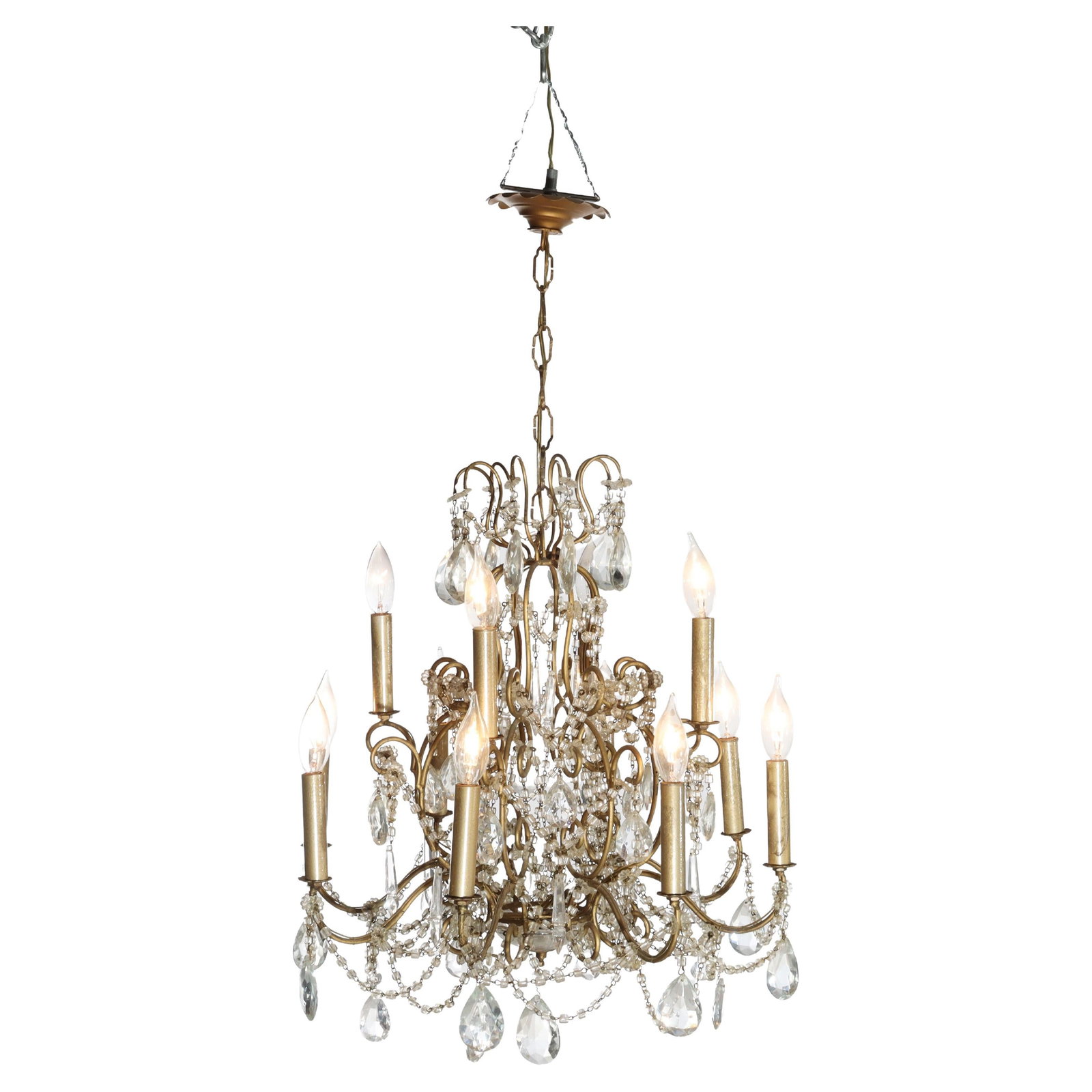 1930 Tiered Brass Chandelier with Crystal Accents and Twelve Lights: 1930 Tiered Brass Chandelier with Crystal Accents and Twelve Lights This antique French Louis XIV style chandelier from circa 1930 features a brass scroll form frame with a tiered design. It is fitted