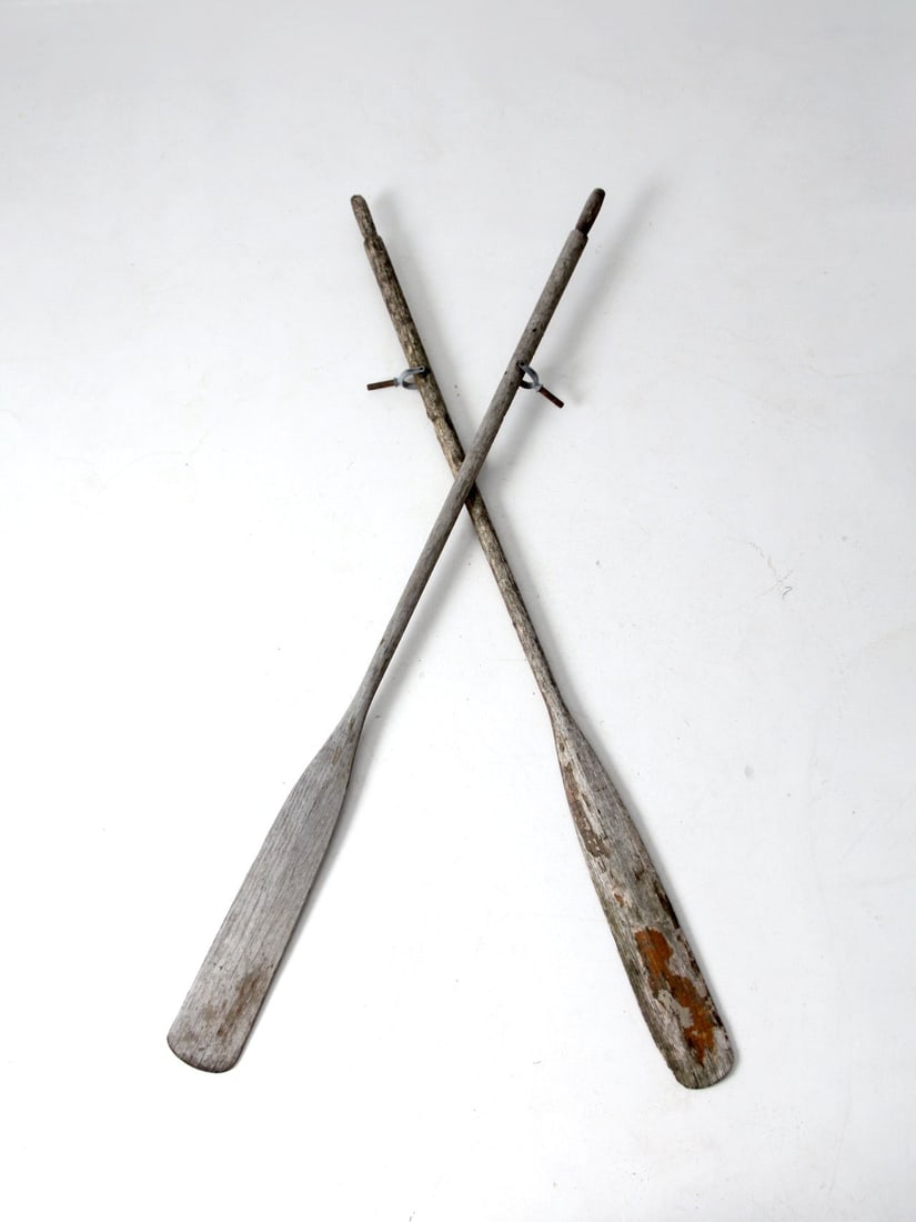 Pair of Antique Distressed Wooden Oars 77.5 Inch: Pair of Antique Distressed Wooden Oars 77.5 Inch This pair of antique wooden oars showcases a charming distressed finish, revealing the natural wood beneath a gray painted exterior. They are in good