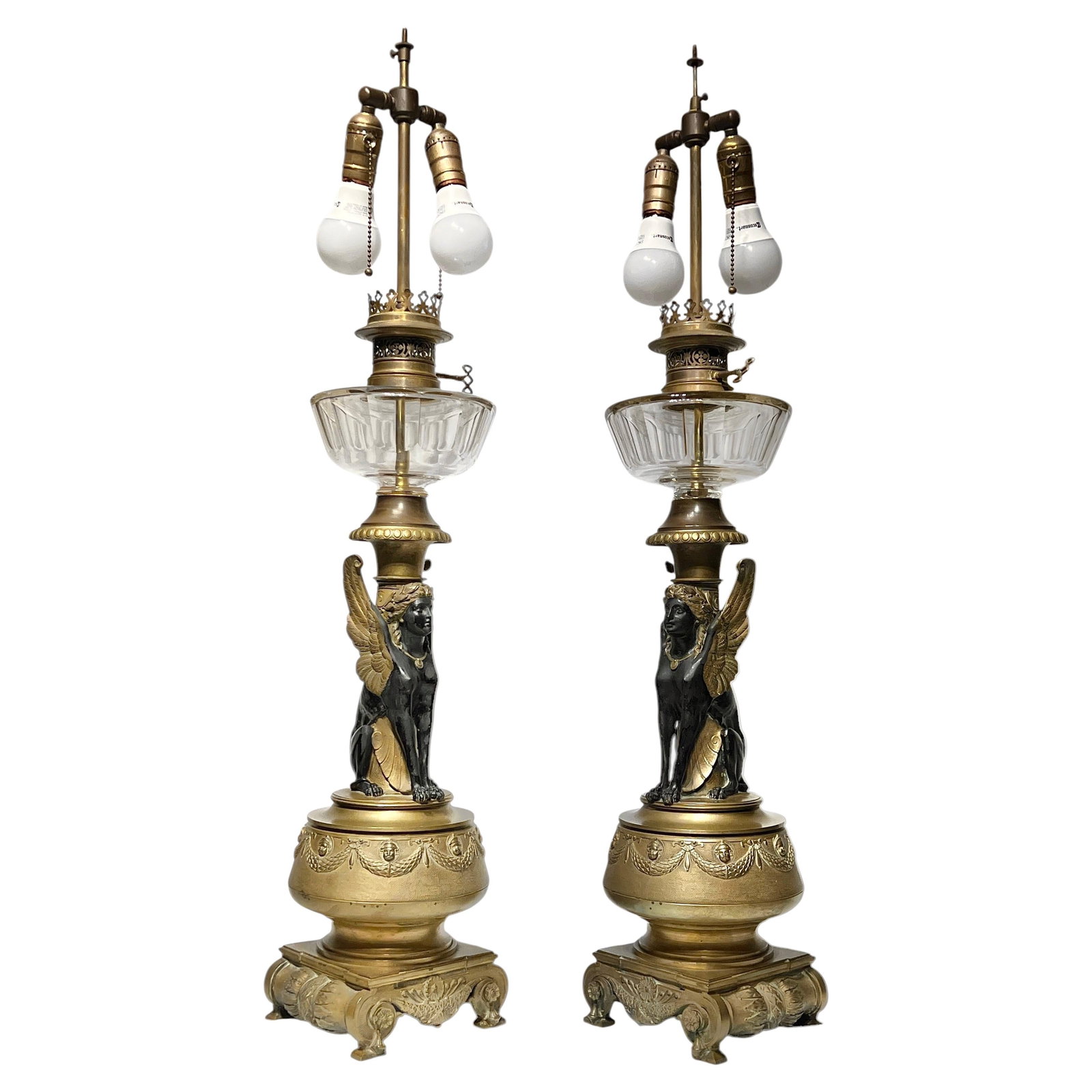 Set of Two Gilt Bronze Egyptian Revival Table Lamps France 19th Century: Set of Two Gilt Bronze Egyptian Revival Table Lamps France 19th Century This pair of late 19th-century table lamps showcases the Egyptian Revival style, crafted in France from gilt bronze and glass. O