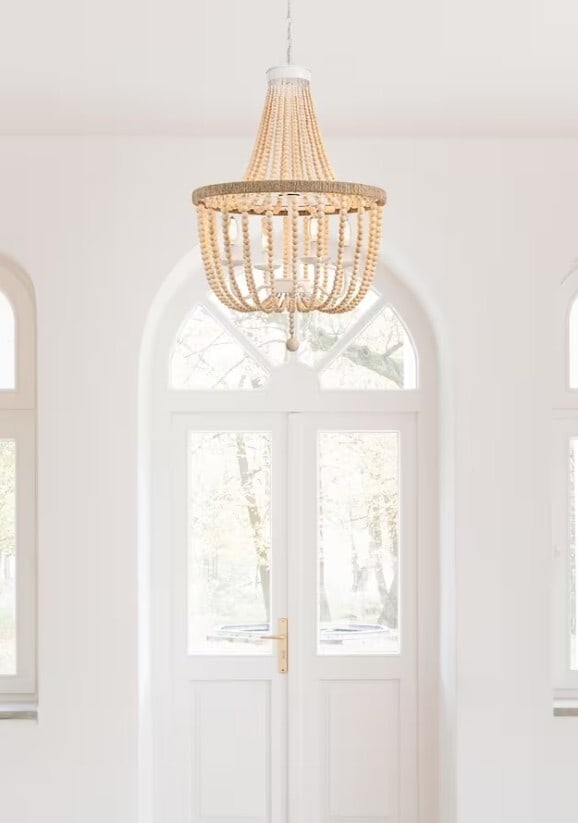 Living District 4 Light Beige White Rope Wood Chandelier: Living District 4 Light Beige White Rope Wood Chandelier This farmhouse-style chandelier features a chic combination of beige wood beads and hand-knotted rope, creating a vintage-inspired look. Design
