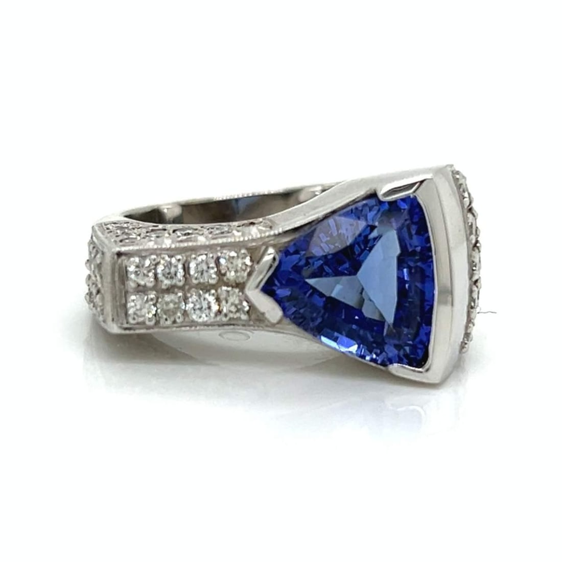 14K White Gold 5.80 Ct Tanzanite Diamond Ring Size 9: 14K White Gold 5.80 Ct Tanzanite Diamond Ring Size 9 This stunning 14K white gold ring showcases a remarkable 5.80 Ct. trillion-cut tanzanite at its center, elegantly complemented by 51 diamonds that 