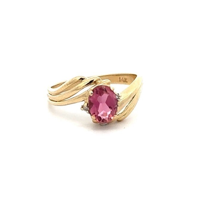 14k Yellow Gold Pink Tourmaline Diamond Accent Solitaire Ring: 14k Yellow Gold Pink Tourmaline Diamond Accent Solitaire Ring This stunning 14k yellow gold ring features a captivating oval pink tourmaline as the centerpiece, elegantly enhanced by two round brillia
