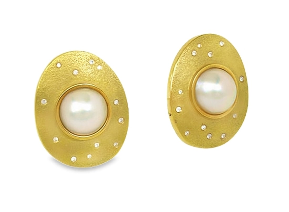 Vintage 18k Yellow Gold Mabe Pearl Diamond Huggie Earrings: Vintage 18k Yellow Gold Mabe Pearl Diamond Huggie Earrings These vintage earrings are crafted in 18k yellow gold and feature luminous mabe pearls, each approximately 12.5mm in size, set within sculptu
