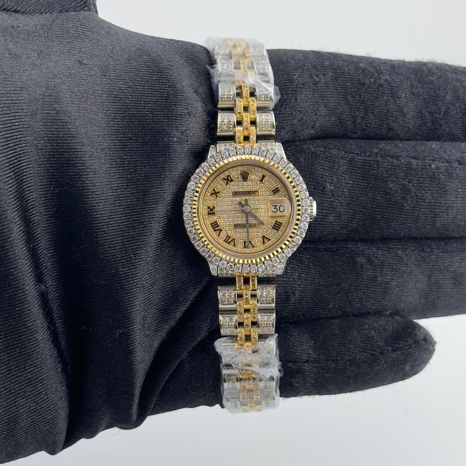 Ladies Rolex Datejust 6517 Aftermarket Iced Roman Dial Jubilee Bracelet: Ladies Rolex Datejust 6517 Aftermarket Iced Roman Dial Jubilee Bracelet This ladies' Rolex Datejust features an aftermarket iced-out Roman numeral dial and an aftermarket Jubilee bracelet set with sto