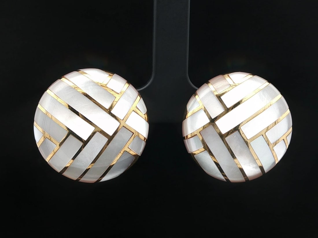 Angela Cummings 18k Gold Clip On Earrings with Mother of Pearl Inlay: Angela Cummings 18k Gold Clip On Earrings with Mother of Pearl Inlay Elevate your accessory collection with these stunning Angela Cummings clip-on earrings. Crafted from solid 18k yellow gold, these e